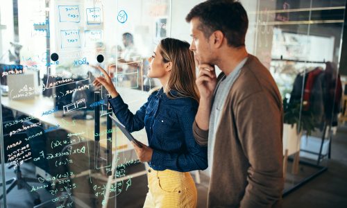 Business solutions, technology and strategy concept. Colleagues working and brainstorming in office