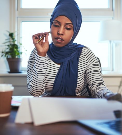 Young Arabic female entrepreneur reading documents in her home office Young Arabic female entrepreneur reading documents in her home office